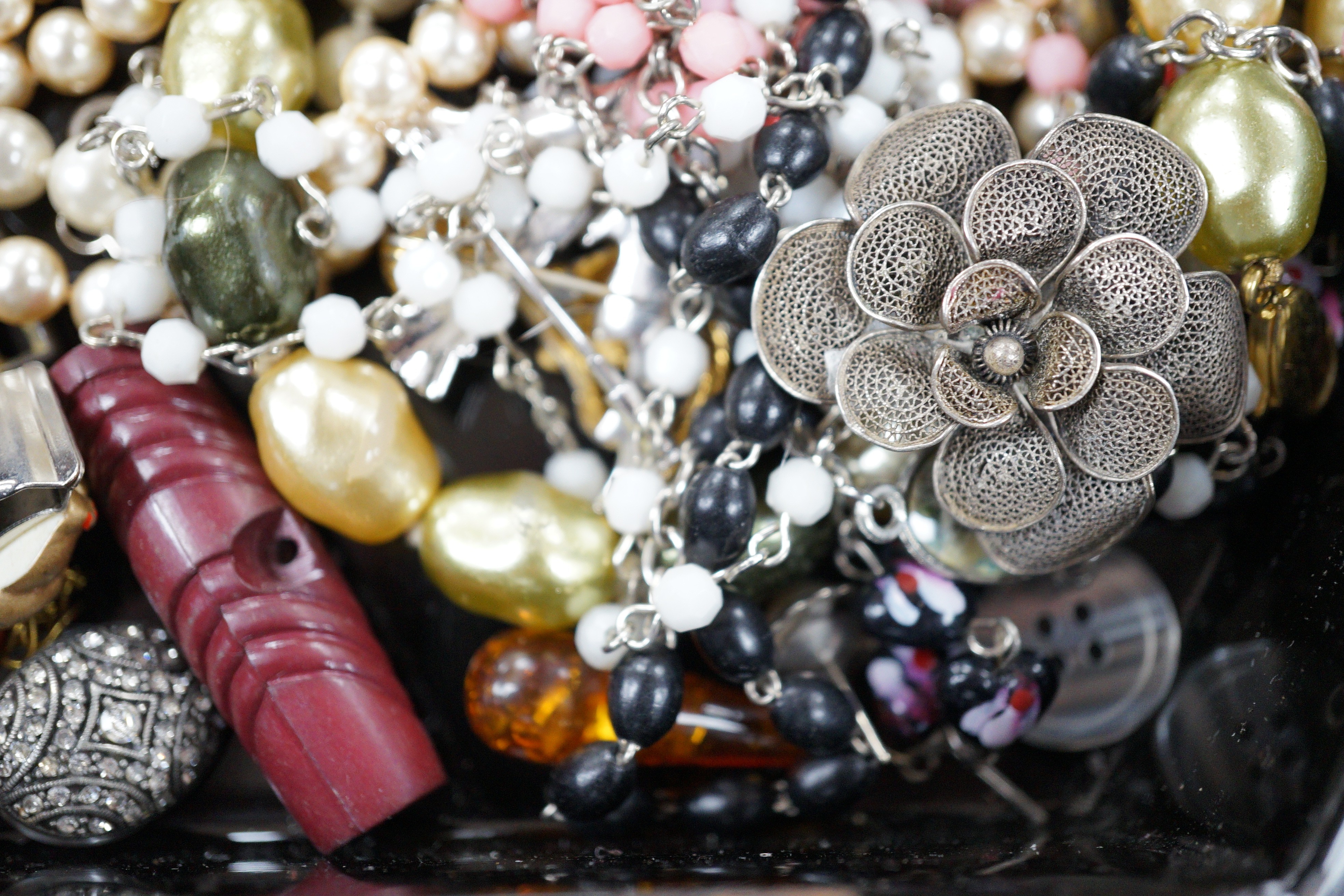 A quantity of assorted costume jewellery in a lacquer box.